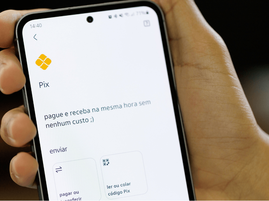 Boleto bancário impresso ao lado de smartphone com app de banco aberto